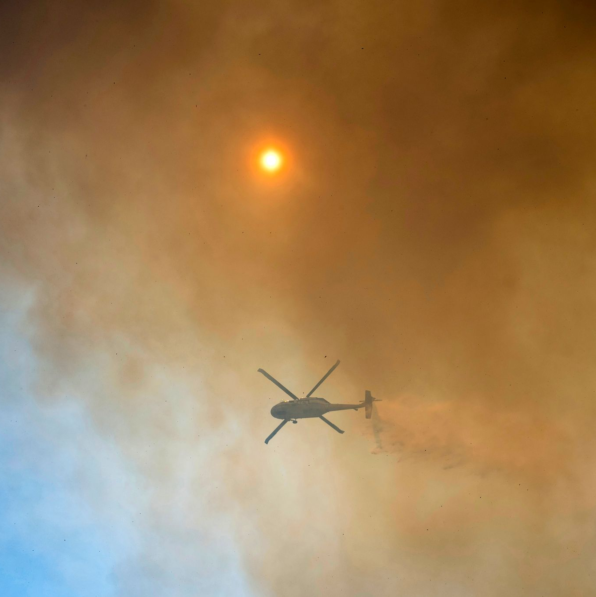 Mit Hubschraubern wird versucht, dem Feuer Herr zu werden.  - Foto: Nic Coury/AP/dpa