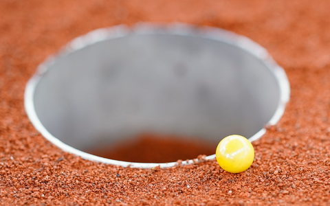 Die Murmeln müssen in das Loch (eine Kuhle) auf dem drei Mal sechs Meter großen Feld befördert werden. - Foto: Uwe Anspach/dpa