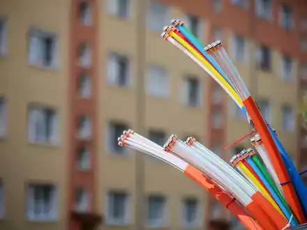 Erst mal angeschlossen, bieten sie Highspeed-Internet: Glasfaserkabel, die aus dem Sockel eines Schaltschranks herausragen. - Foto: Jan Woitas/dpa