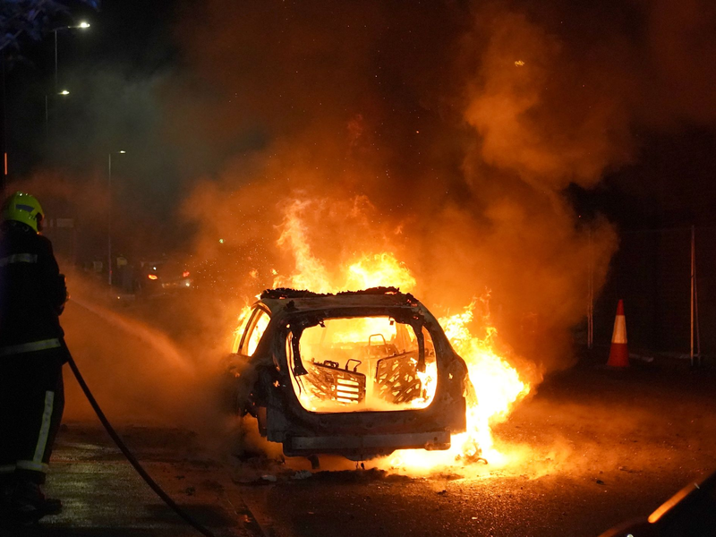 Bei den Krawallen wurde ein Polizeiauto angezündet. - Foto: Owen Humphreys/PA Wire/dpa