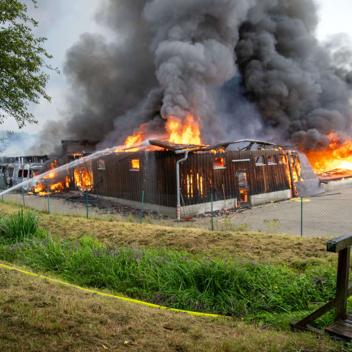 Einsatzkräfte löschen eine brennende Lagerhalle mit Fahrzeugen in Untermerzbach - Foto: Pia Bayer/dpa