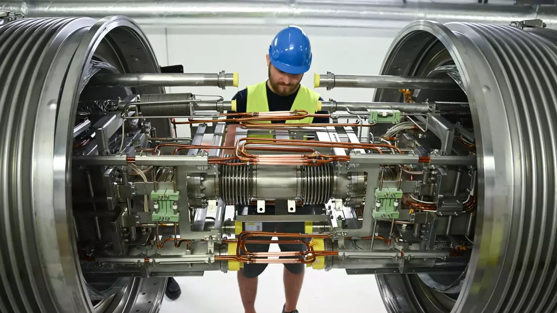 Techniker aus dem In- und Ausland montieren riesige Magnete. - Bild: Arne Dedert/dpa