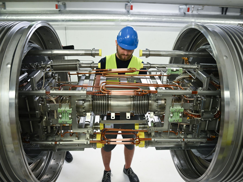 Techniker aus dem In- und Ausland montieren riesige Magnete. - Foto: Arne Dedert/dpa