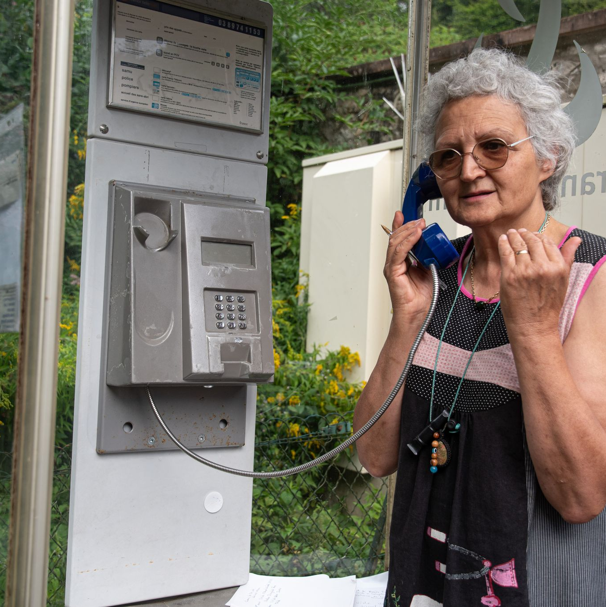 Marie-Claude König nimmt in Murbach einen Anruf entgegen. In der Telefonzelle im Elsass rufen Menschen aus der ganzen Welt an. - Foto: Florian Bodenmüller/SWD - Südwestdeutsches Mediennetzwerk GmbH/dpa