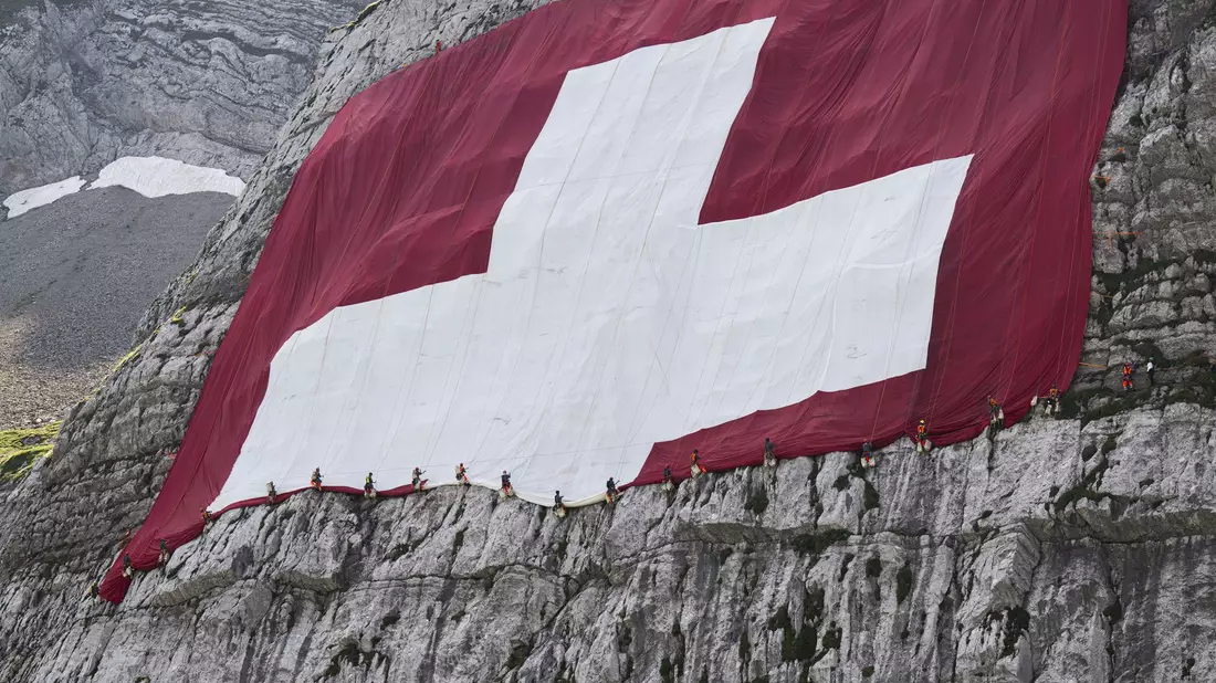 Anfang August wird am Säntis eine riesige Schweizerfahne zum Nationalfeiertag angebracht und danach wieder abgebaut. Höhenarbeiter beteiligten sich am Rettungseinsatz. - Bild: Gian Ehrenzeller/KEYSTONE/dpa