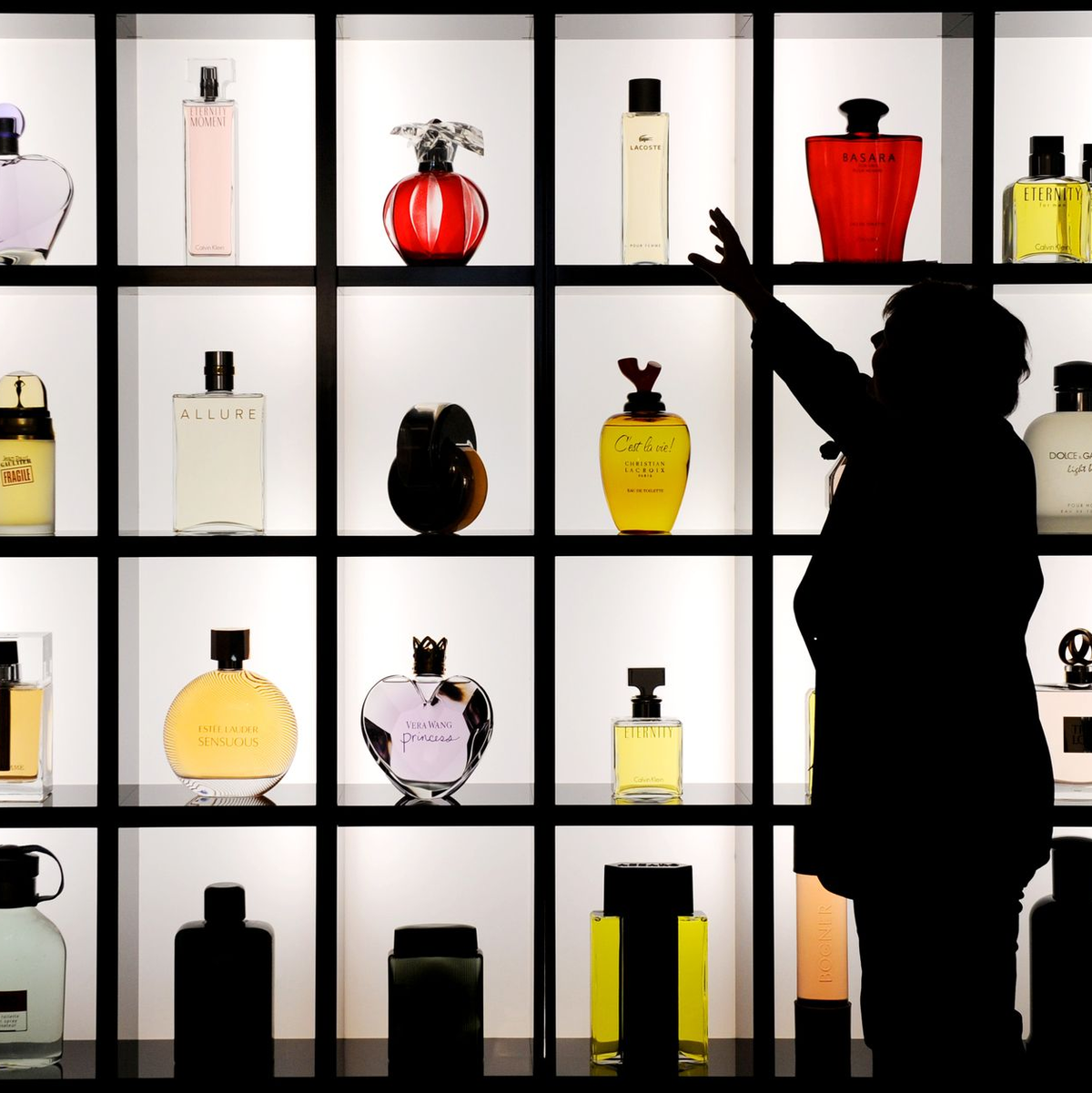 Schöne bunte Parfumwelt: Eine Frau steht vor einer Vitrine mit verschiedenen Flacons. (Archivbild) - Foto: picture alliance / dpa