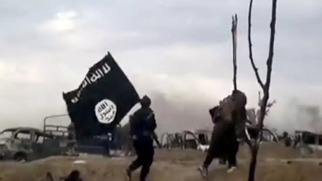 IS-Kämpfer zeigen ihre Fahne.   - Bild: Amaq News Agency/AP/dpa