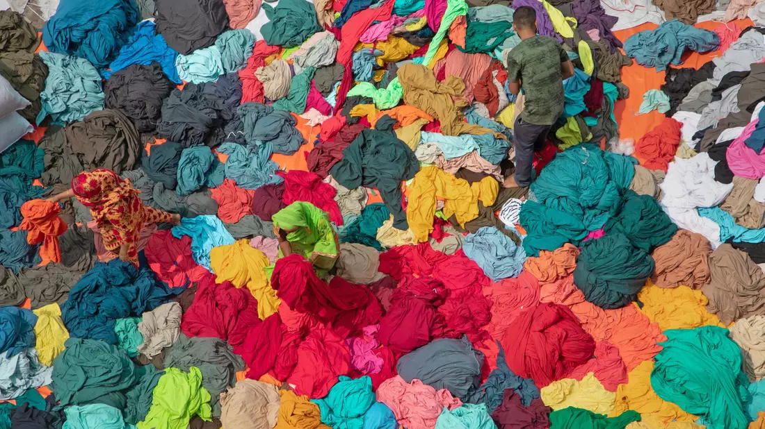 Arbeiter sortieren in Narayanganj, Bangladesch, bunte Stapel von Stoffen, die zu Kleidungsstücken verarbeitet werden sollen. - Bild: Joy Saha/ZUMA Press Wire/dpa