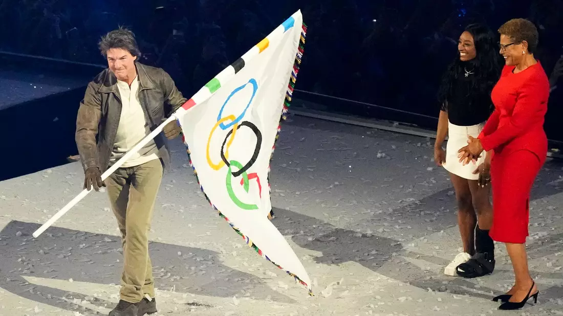 Hollywoodstar Tom Cruise übernahm die olympische Flagge für Los Angeles 2028. - Bild: Rebecca Blackwell/AP/dpa
