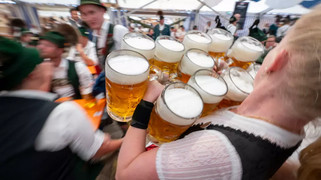Bayern- oder auch Deutschland-Klischee pur: Eine Bedienung trägt in einem Festzelt Maßkrüge - hier beim Gaufest des Chiemgau-Alpenverbands 2024. (Archivbild) - Bild: Peter Kneffel/dpa