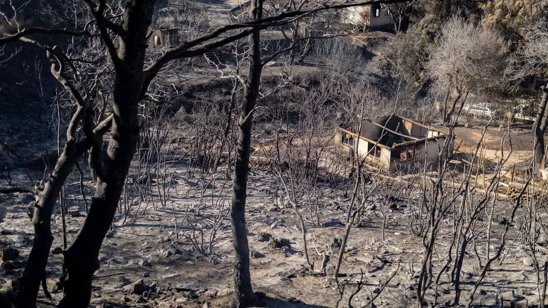 Hausbesitzer begutachten in Ano Patima, was von ihrem Eigenheim übrig geblieben ist.  - Bild: Socrates Baltagiannis/dpa
