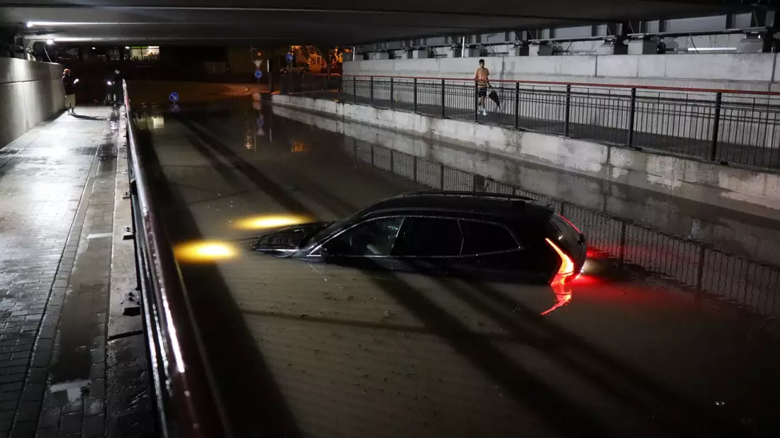 Nach einem schweren Gewitter steht ein Auto in Bruchsal bis zur Motorhaube im Wasser. - Bild: René Priebe/dpa