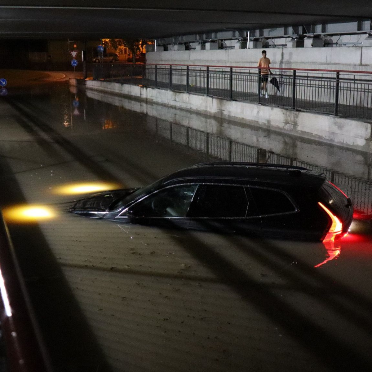 Nach einem schweren Gewitter steht ein Auto in Bruchsal bis zur Motorhaube im Wasser. - Foto: René Priebe/dpa