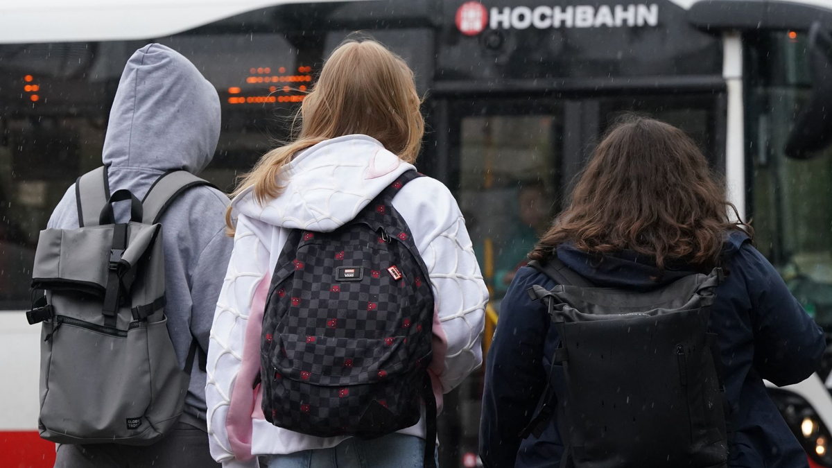 Zwei Schülerinnen und ein Schüler warten in Hamburg auf einen Bus. (Symbolbild) - Foto: Marcus Brandt/dpa