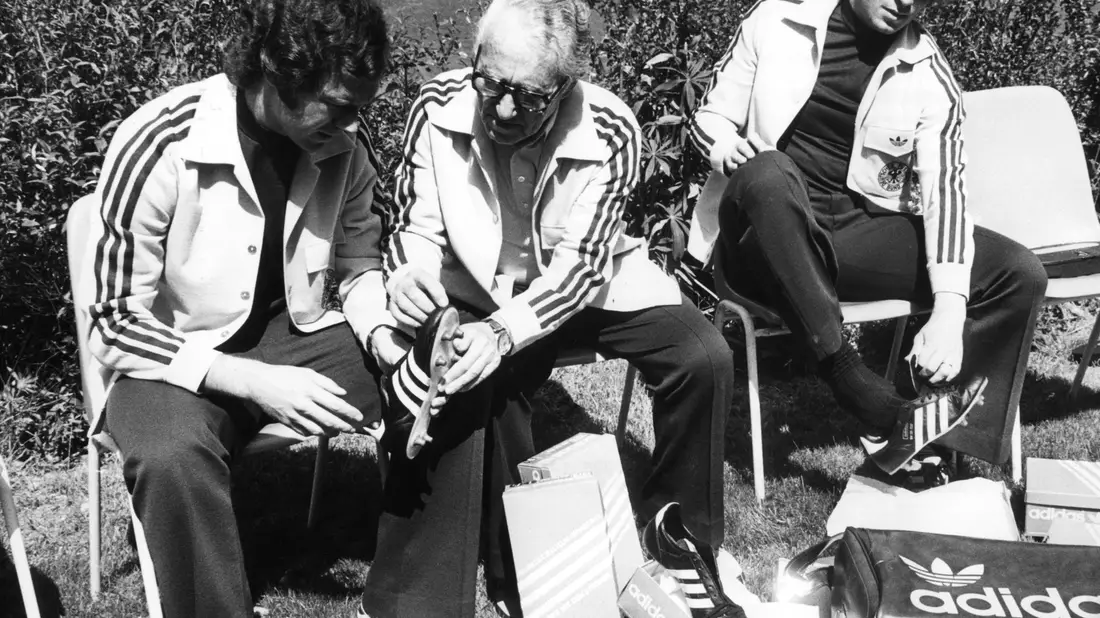 Adi Dassler (Mitte) galt lange Zeit als Pionier der Sportschuh-Welt. Das von ihm gegründete Unternehmen Adidas wird 75 Jahre alt. (Archivbild) - Bild: Werner Baum/dpa
