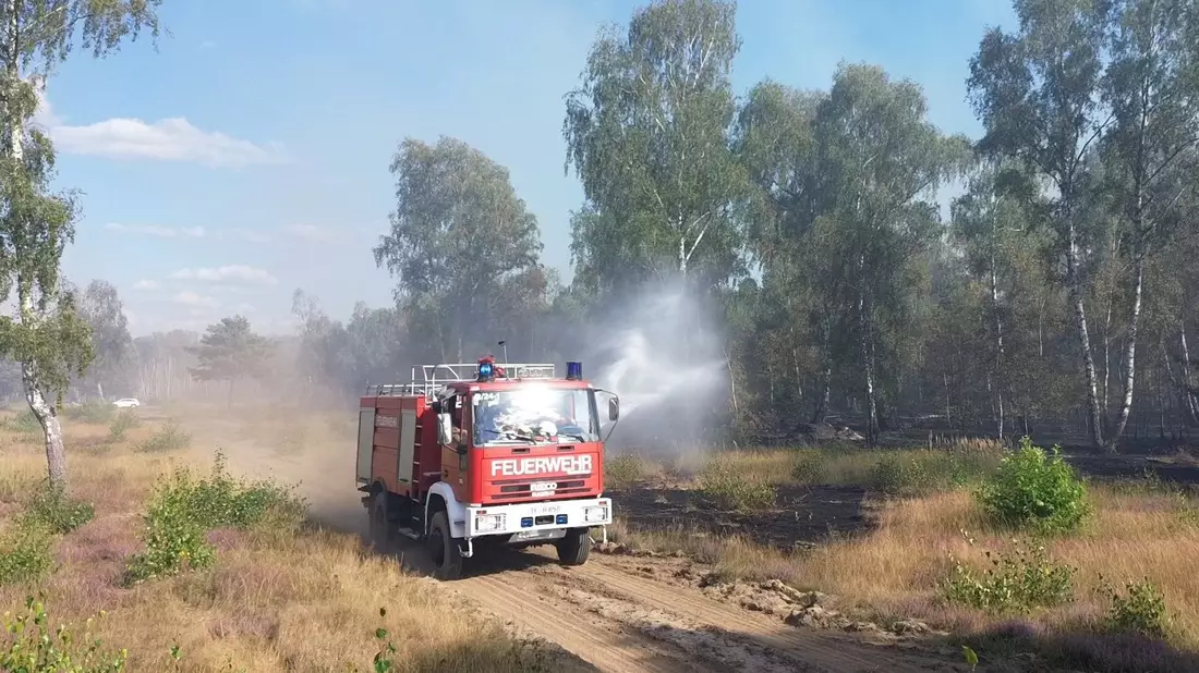 Die Feuerwehr löscht von Wegen aus beim Waldbrand in Jüterbog.  - Bild: Cevin Dettlaff/dpa