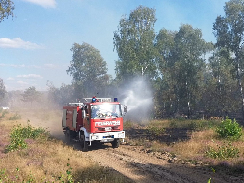 Die Feuerwehr löscht von Wegen aus beim Waldbrand in Jüterbog.  - Foto: Cevin Dettlaff/dpa