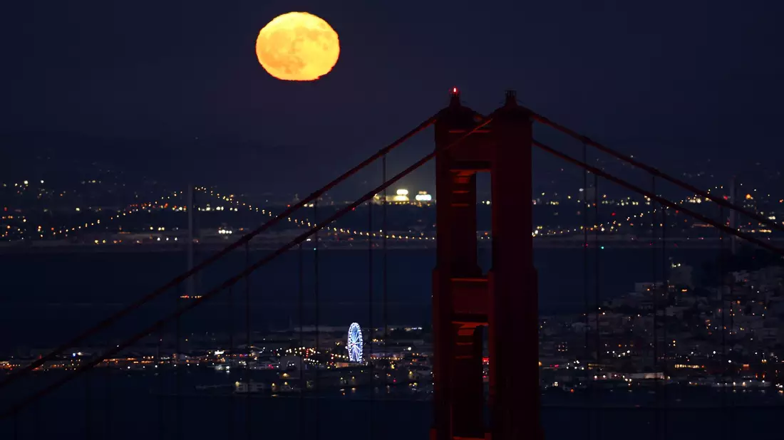 Hinter der Golden Gate Bridge ist am Himmel ein goldfarbener Vollmond zu sehen - Bild: Scott Strazzante/San Francisco Chronicle/AP/dpa