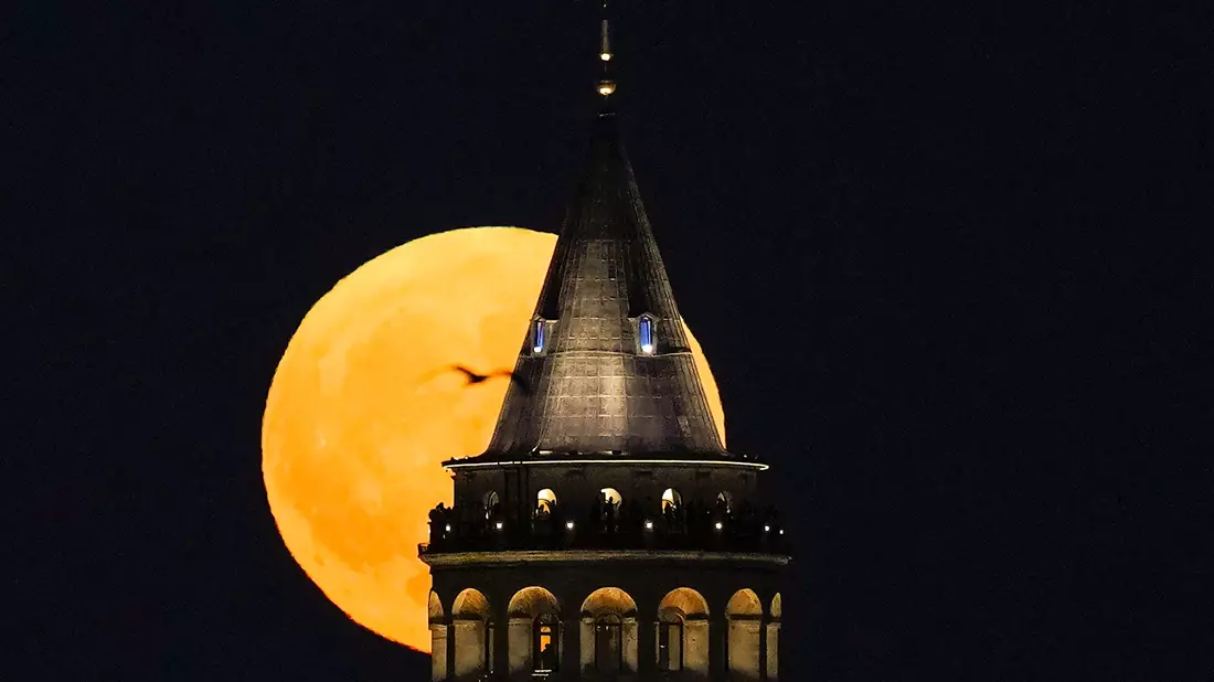 Ein Supermond geht hinter dem Galata-Turm in Istanbul auf. - Bild: Khalil Hamra/AP/dpa