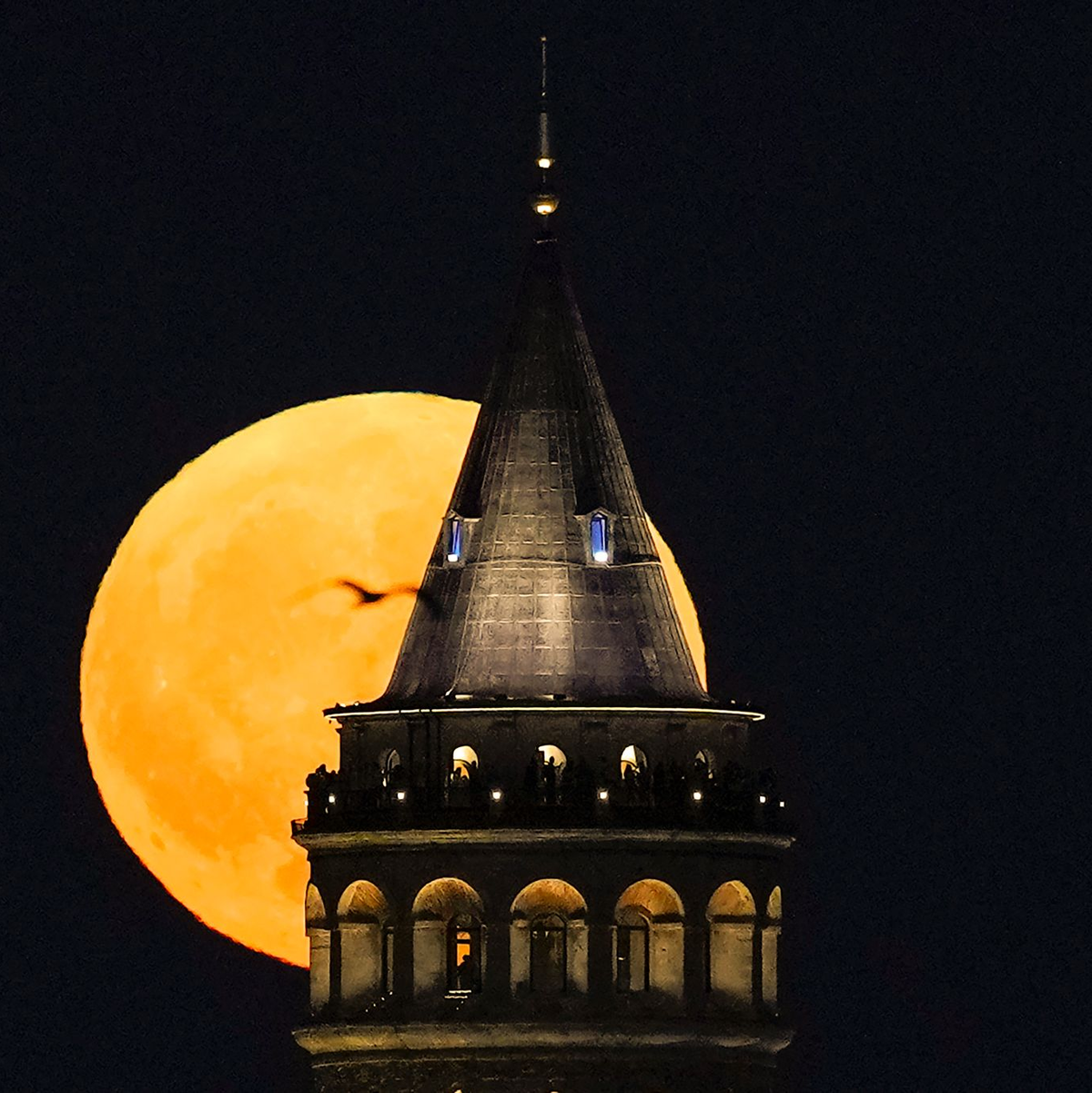 Ein Supermond geht hinter dem Galata-Turm in Istanbul auf. - Foto: Khalil Hamra/AP/dpa