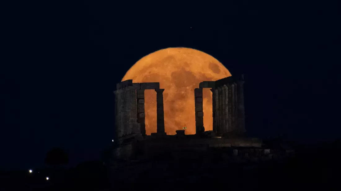 Der Supermond geht hinter dem Poseidon-Tempel am Kap Sounio südlich von Athen auf. - Bild: Michael Varaklas/AP/dpa