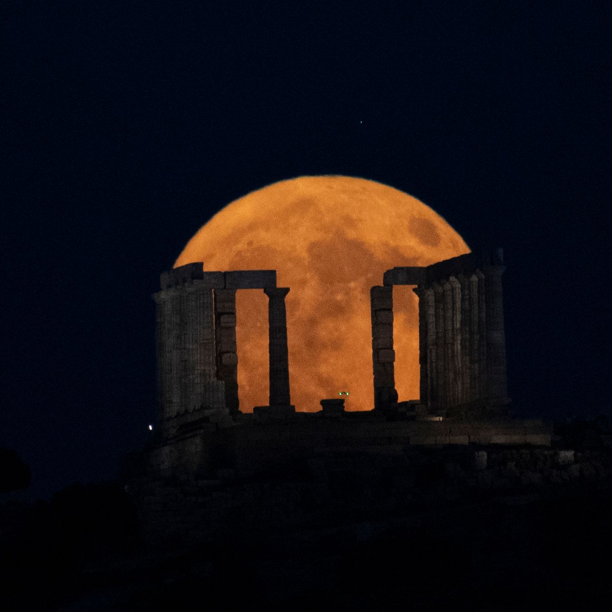 Der Supermond geht hinter dem Poseidon-Tempel am Kap Sounio südlich von Athen auf. - Foto: Michael Varaklas/AP/dpa
