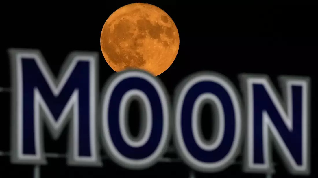 Der Vollmond geht über einem Bierschild im Kauffmann Stadium in Kansas City auf. - Bild: Charlie Riedel/AP