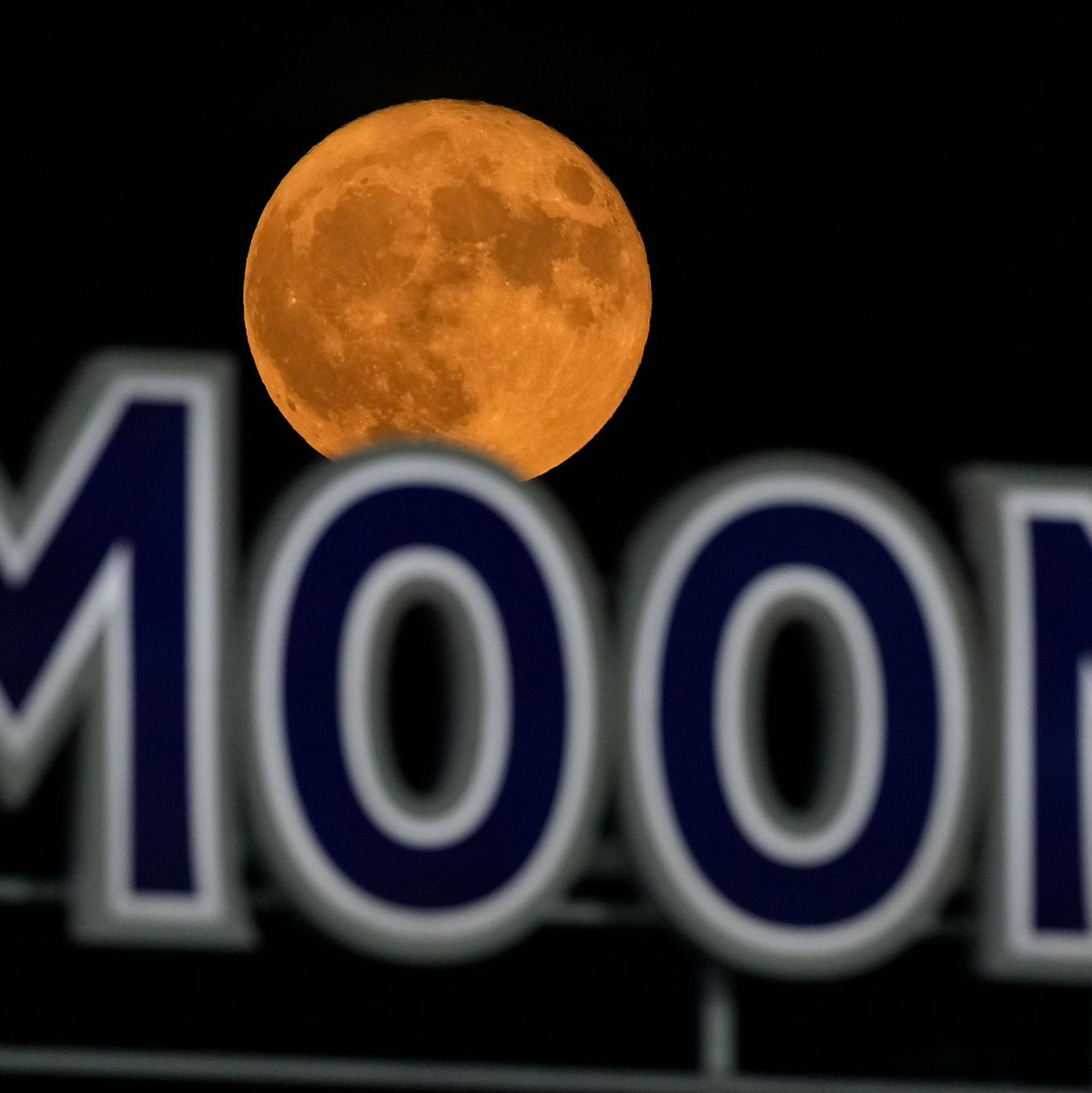 Der Vollmond geht über einem Bierschild im Kauffmann Stadium in Kansas City auf. - Foto: Charlie Riedel/AP