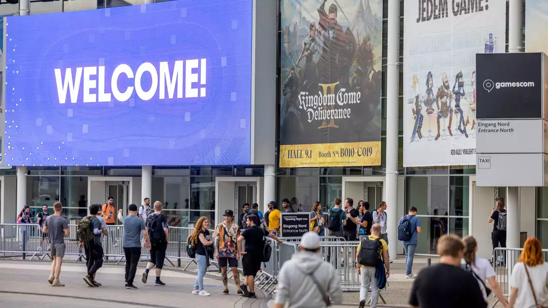Besucher der Eröffnungsshow der Gamescom gehen zum Eingang der Kölner Messe. - Bild: Thomas Banneyer/dpa