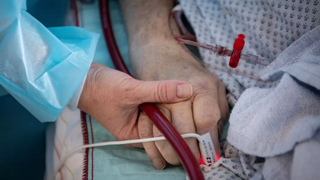 Angehörige sprechen häufig mit Schwerkranken, auch wenn diese nicht reagieren. - Bild: Boris Roessler/dpa