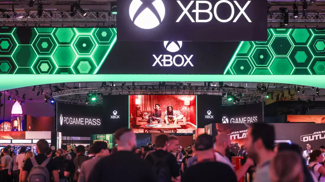 Menschen warten vor dem Gamescom-Stand von Microsoft Xbox. - Bild: Oliver Berg/dpa