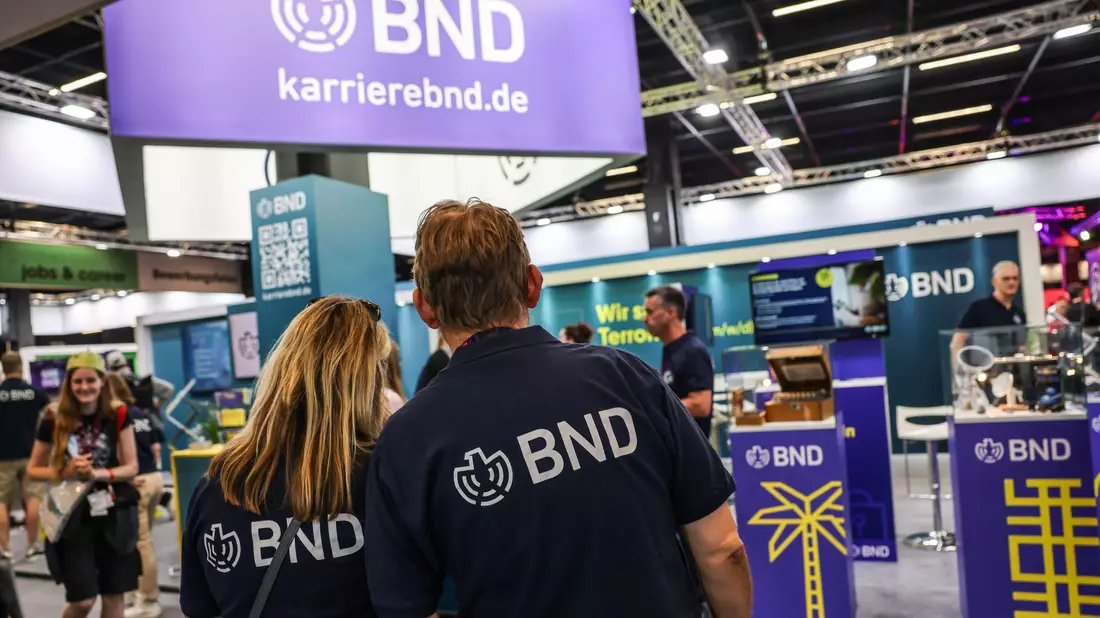 Mitarbeiter des BND stehen am Gamescom-Messestand ihrer Behörde. Die Bundesbehörde zählt circa 6.500 Beschäftigte. - Bild: Oliver Berg/dpa