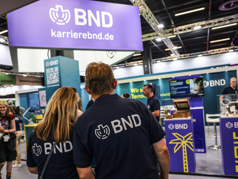 Mitarbeiter des BND stehen am Gamescom-Messestand ihrer Behörde. Die Bundesbehörde zählt circa 6.500 Beschäftigte. - Foto: Oliver Berg/dpa