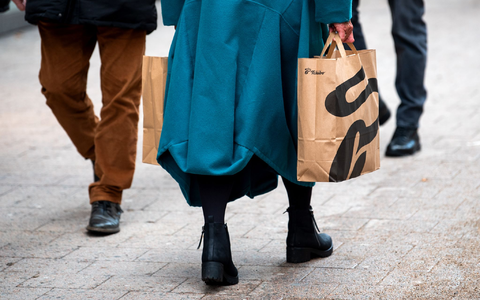 Eine Frau mit Einkaufstüten geht durch die Hamburger Innenstadt. - Foto: Daniel Bockwoldt/dpa