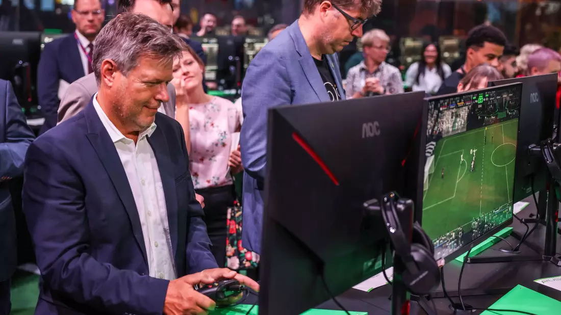 Der Bundeswirtschaftsminister Robert Habeck und sein Staatssekretär Michael Kellner (beide Grüne) spielen bei der Gamescom ein Fußballspiel zur Probe. - Bild: Oliver Berg/dpa