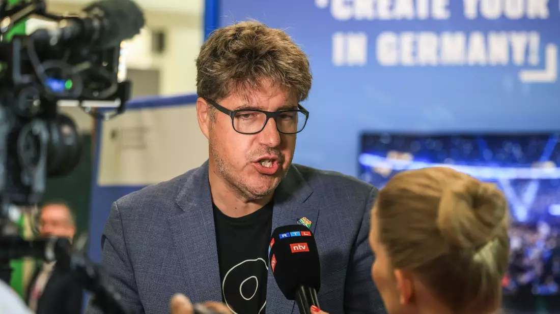 Der Staatssekretär im Bundeswirtschaftsministerium, Michael Kellner (Grüne), spricht mit einer Journalistin. - Bild: Oliver Berg/dpa