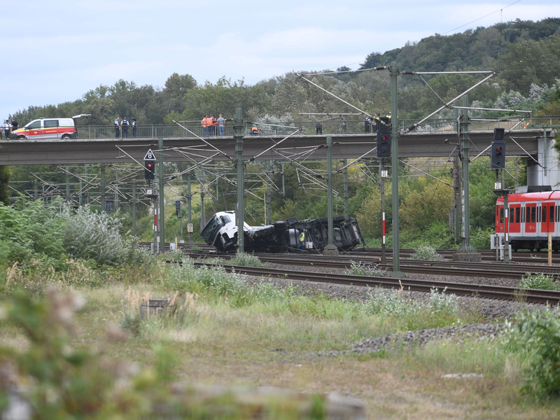 An einem Bahnhof in Kerpen westlich von Köln ist ein Lastwagen von einer Brücke auf Gleise gestürzt. - Foto: Vincent Kempf/dpa
