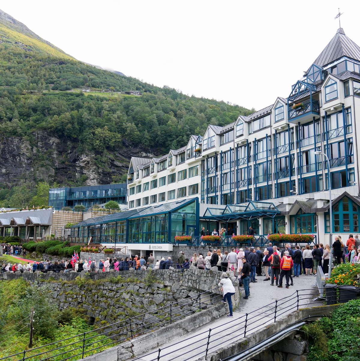 Hotelangestellte schirmen das Brautpaar vor Blicken ab. - Foto: Heiko Junge/NTB/dpa