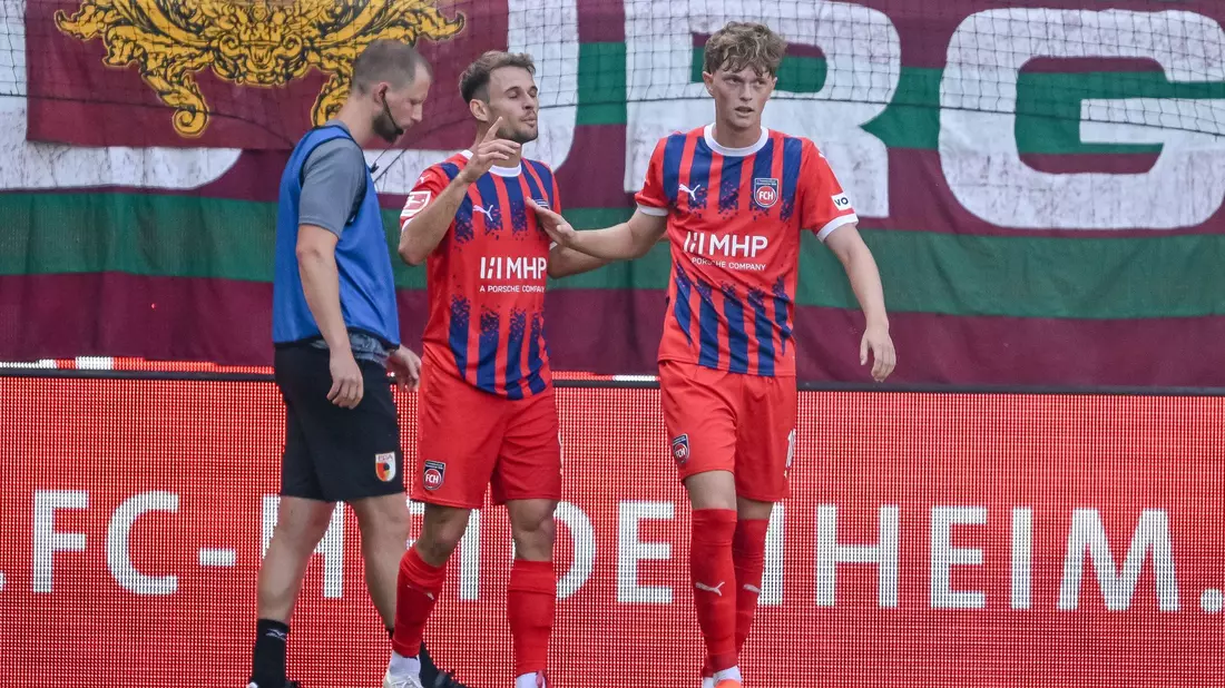 In dieser Szene berührt Augsburgs Schlotterbeck den Ball mit dem linken Arm. Die Folge: Handelfmeter für Heidenheim. - Bild: Harry Langer/dpa
