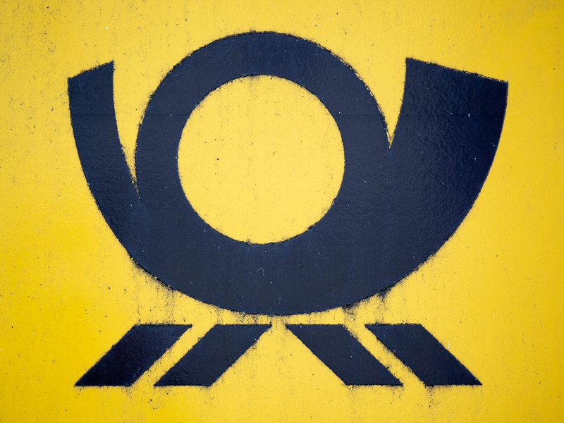 Blick auf einen Briefkasten der Deutschen Post, auf dem das Posthorn-Logo zu sehen ist. - Foto: Hendrik Schmidt/dpa