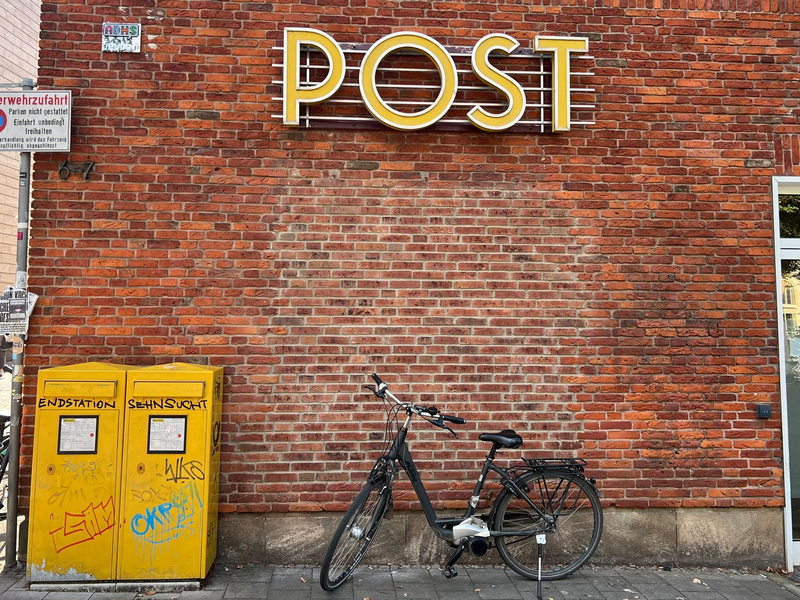 Eine Briefträgerin fährt an einer Postfiliale vorbei - vielleicht ist auch sie eine Beamtin? - Foto: Wolf von Dewitz/dpa