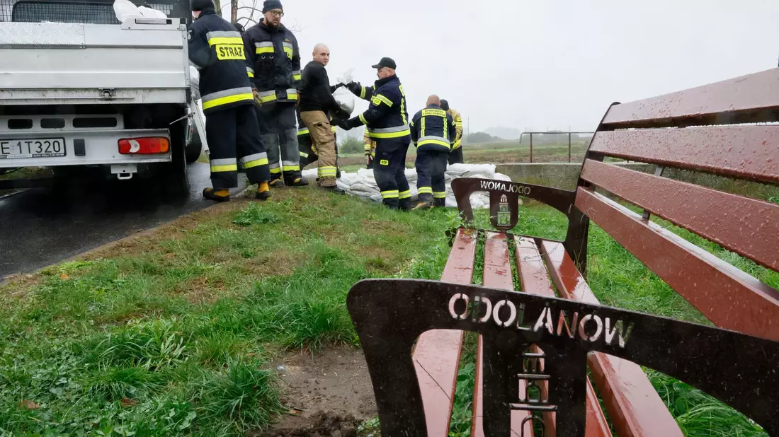 Feuerwehrleute in Polen errichten mit Sandsäcken eine Barriere gegen das drohende Hochwasser in der Nähe des Flusses Barycz in Odolanow. - Bild: Tomasz Wojtasik/PAP/dpa