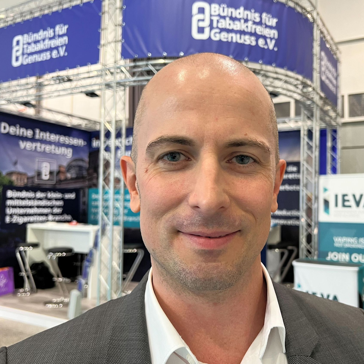 Dustin Dahlmann, Vorsitzender des E-Zigaretten-Verbandes «Bündnis für Tabakfreien Genuss» (BfTG), steht bei der Messe Intertabac 2023 vor einem Stand seiner Organisation. - Foto: Wolf von Dewitz/dpa