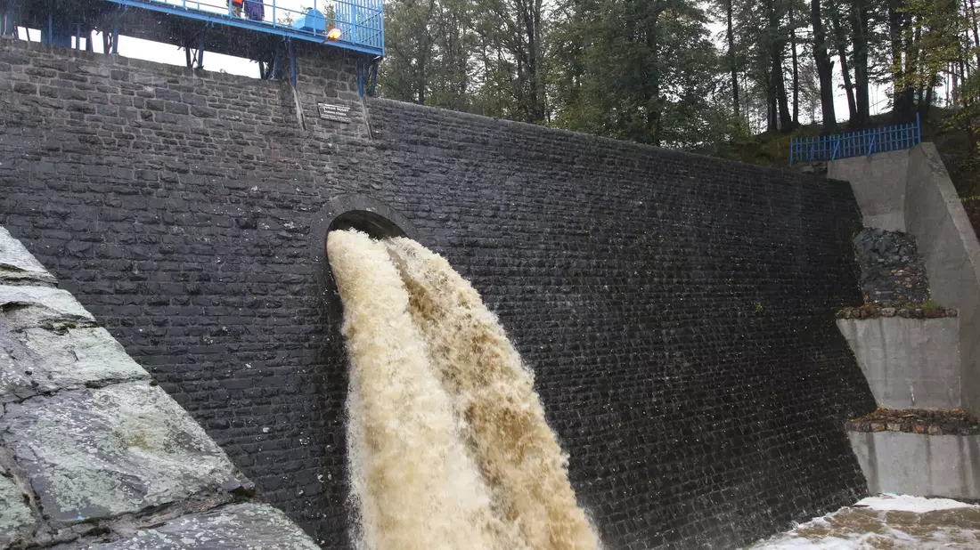 Der hohe Wasserstand des Flusses Zloty Potok im Südwesten Polens strömt durch eine Sperrmauer. Die Region um die Stadt Oppeln ist am stärksten vom Unwetter betroffen. - Bild: Krzysztof Swiderski/PAP/dpa