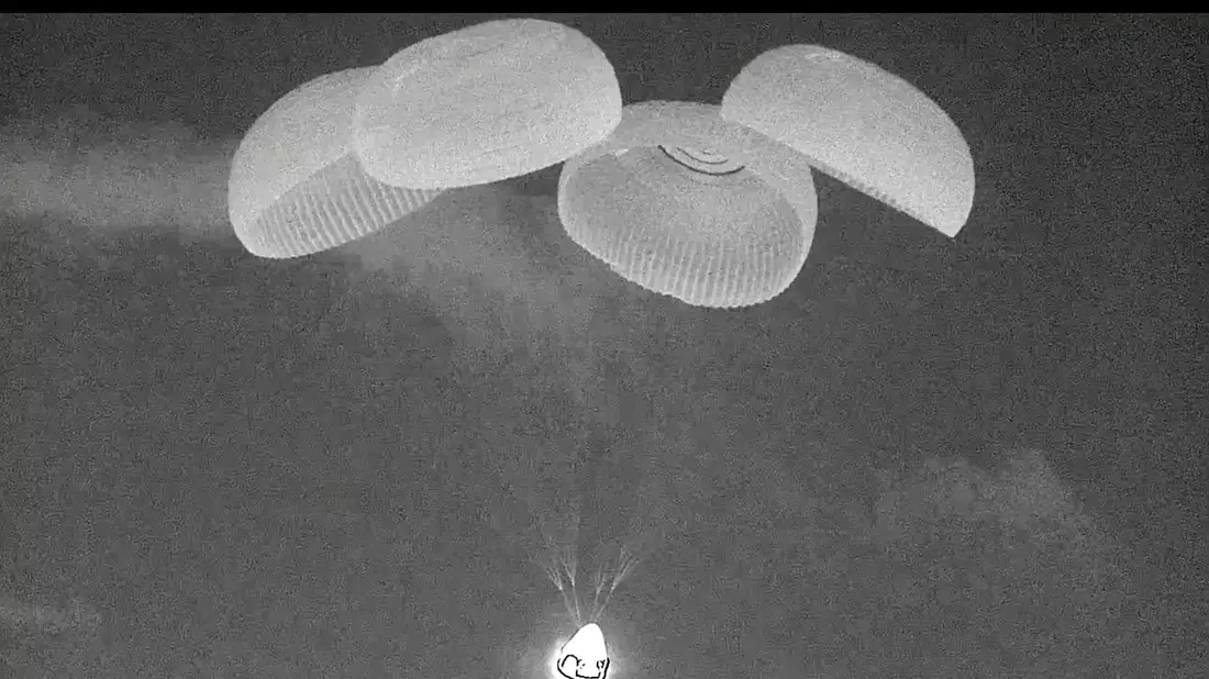 An Fallschirmen hängend trifft Crew Dragon auf dem Meer auf. - Bild: Uncredited/SpaceX/AP