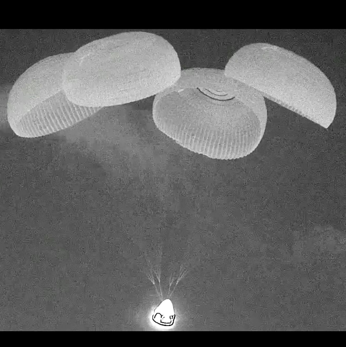 An Fallschirmen hängend trifft Crew Dragon auf dem Meer auf. - Foto: Uncredited/SpaceX/AP