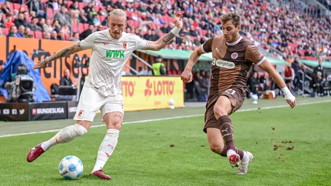 Augsburgs Marius Wolf (links) im Zweikampf mit Pauli-Profi Lars Ritzka. - Bild: Harry Langer/dpa