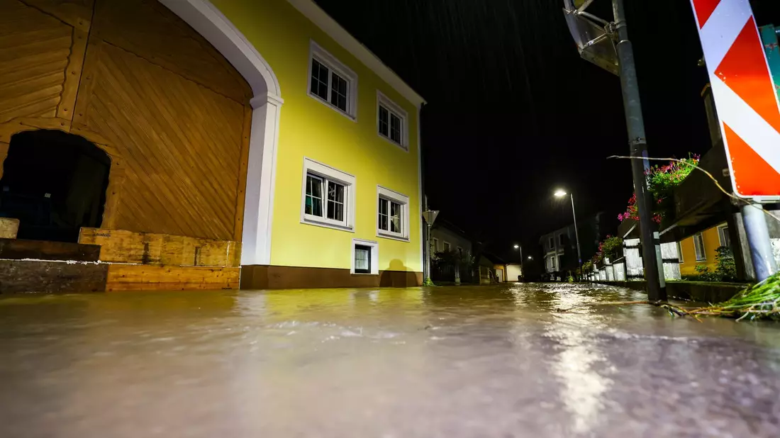 In Österreich helfen Freiwillige beim Befüllen von Sandsäcken. - Bild: Christoph Reichwein/dpa