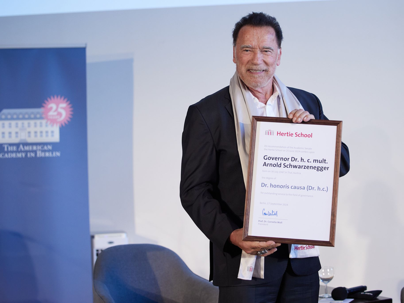 Arnold Schwarzenegger bekommt von Cornelia Woll und Robert Habeck die Ehrendoktorwürde überreicht. - Foto: Joerg Carstensen/dpa