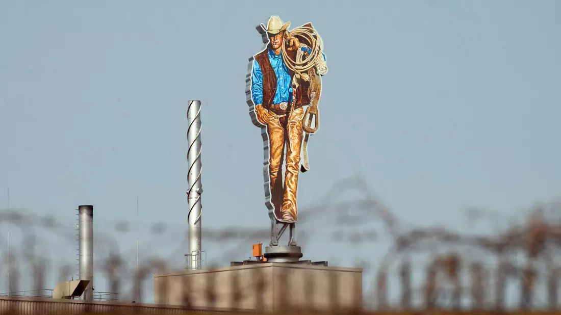 Die Werbefigur der Zigarettenmarke Marlboro, der «Marlboro-Mann», steht auf dem Gebäude der Philip Morris GmbH. - Bild: Soeren Stache/dpa
